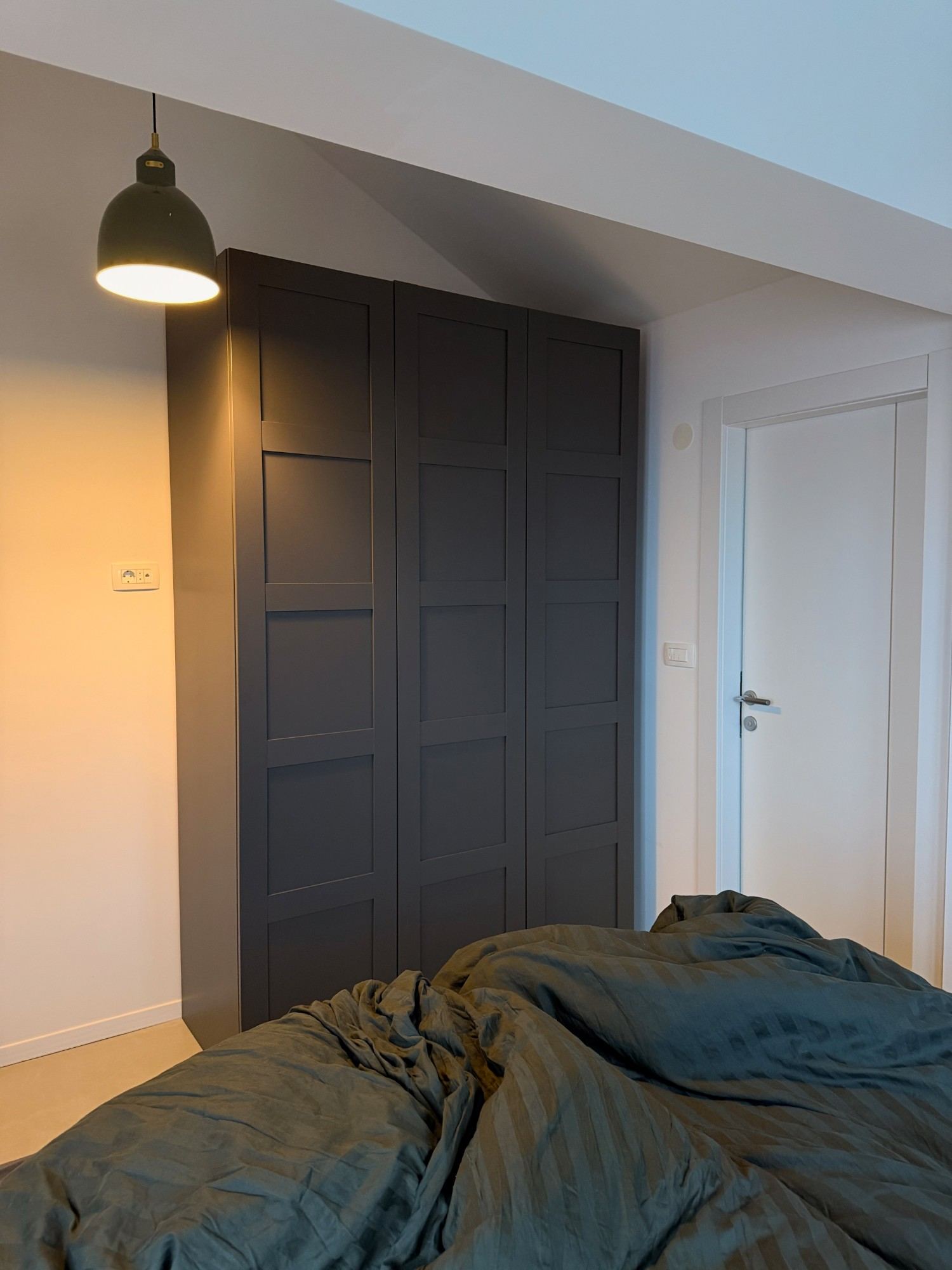 Bedroom with built-in wardrobe under the sloped ceiling