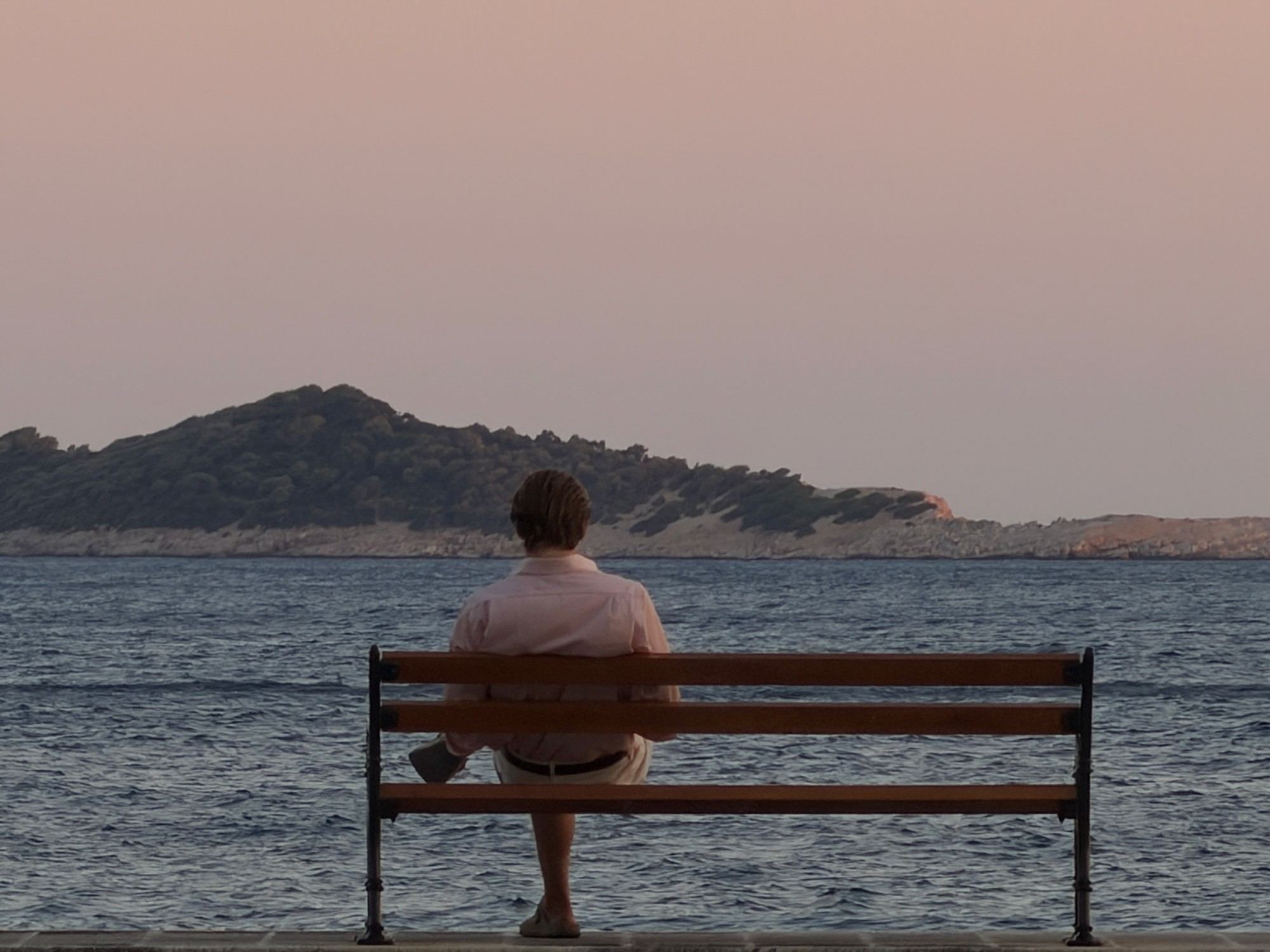 Sitting on the waterfront bench looking out at the bay at dusk