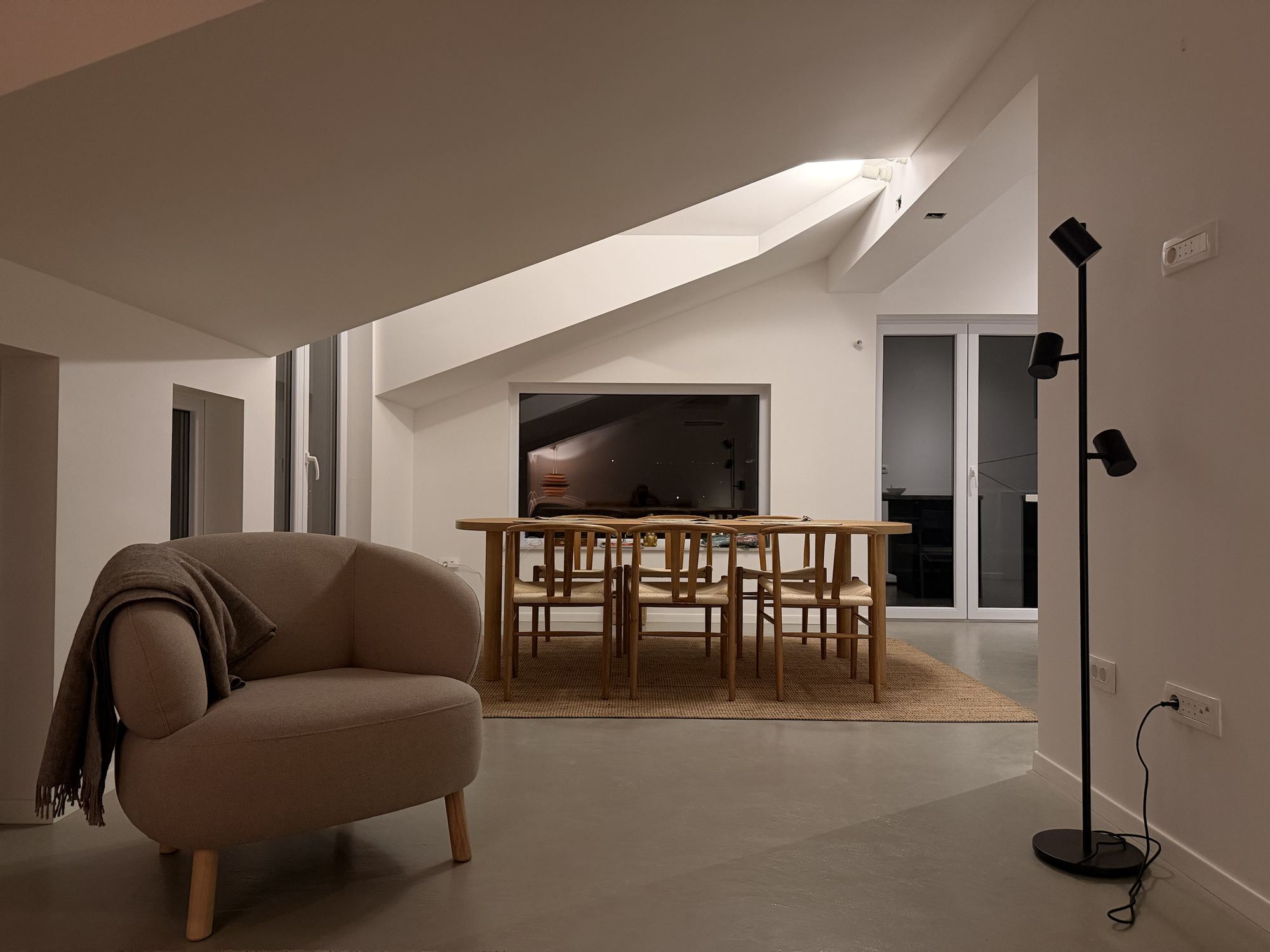 Dining table and living area, with the sea-facing window behind