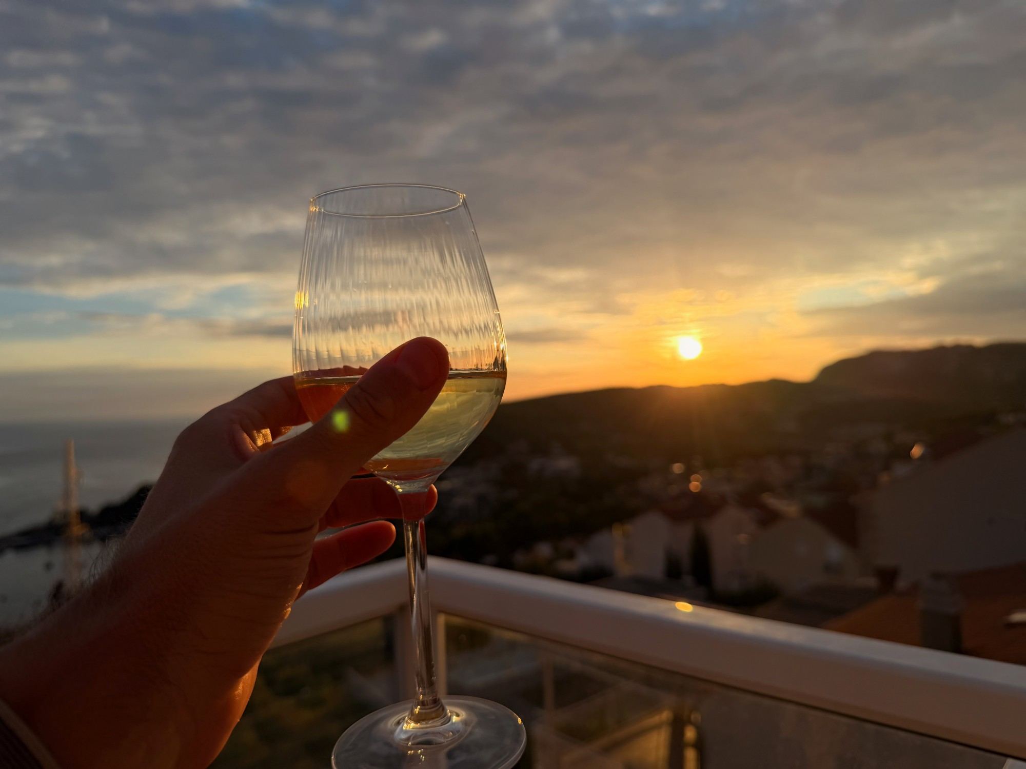 A glass of wine on the terrace at sunset overlooking the village